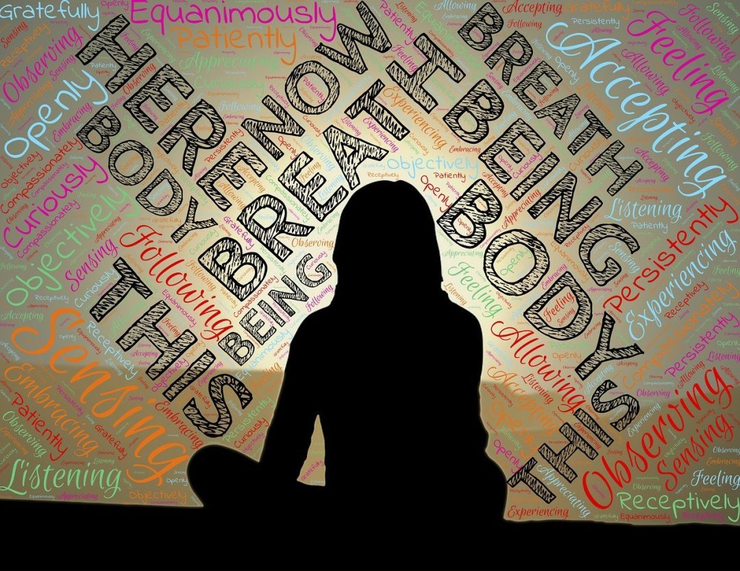 silhouette of woman meditation and the words be here now are written on background