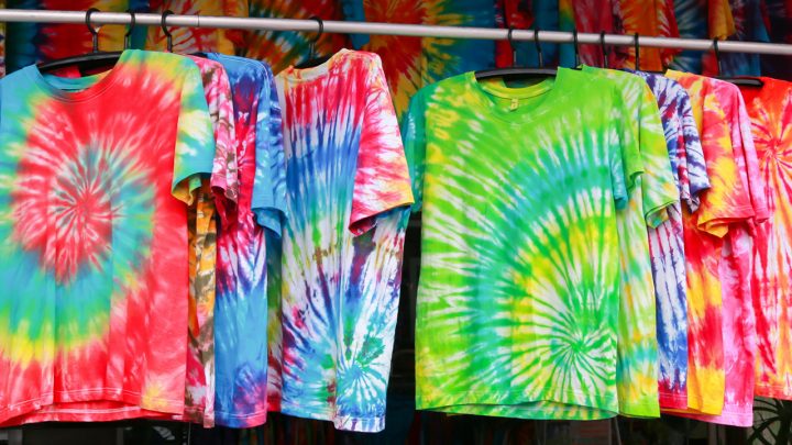 5 tie dyed shirts hanging on a rack